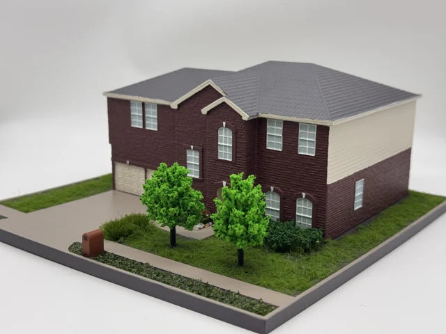 Red brick house model with arched windows, grey roof, double garage, two front trees and a walkway beside the lawn.